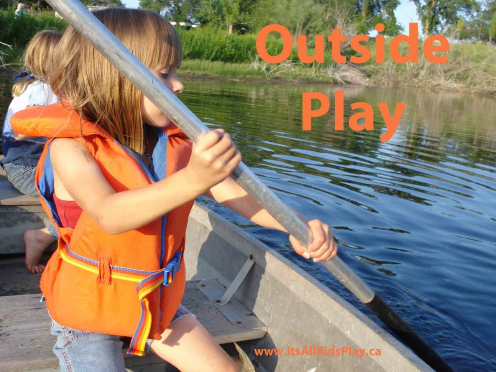 Outside Play. Kids paddling a boat in a pond.