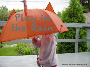 Play in the rain. Child under an umbrella.